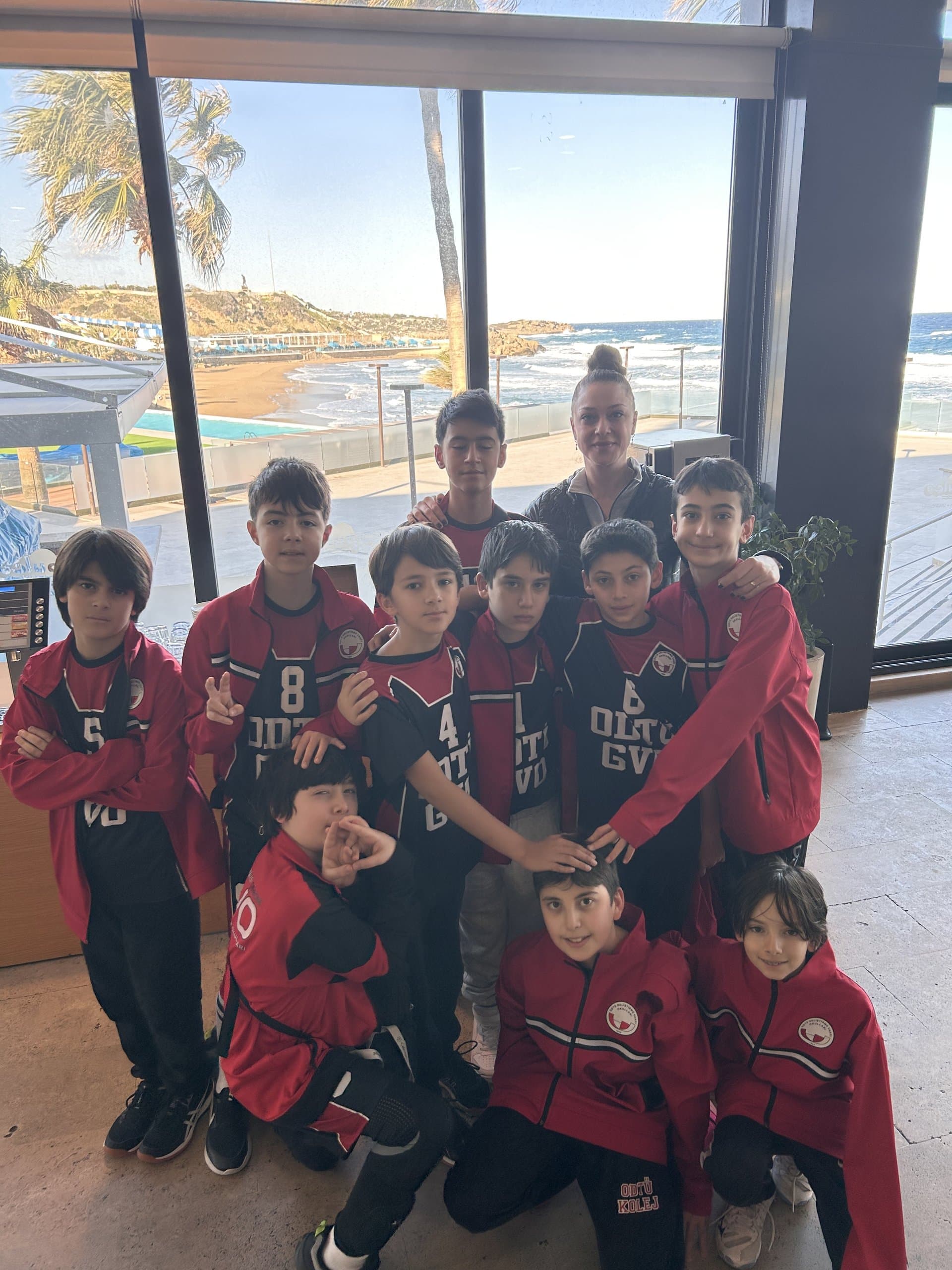A HighFive youth team and their coach gathered together by the sea after a session