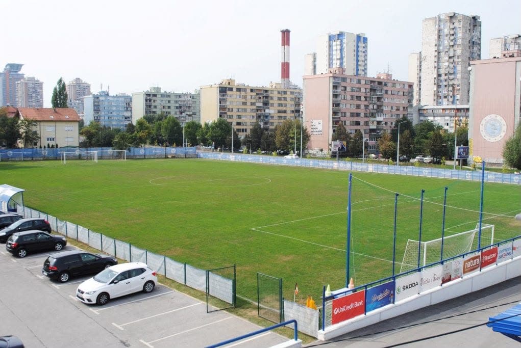 Grass match pitch with stands and pitch-side boards